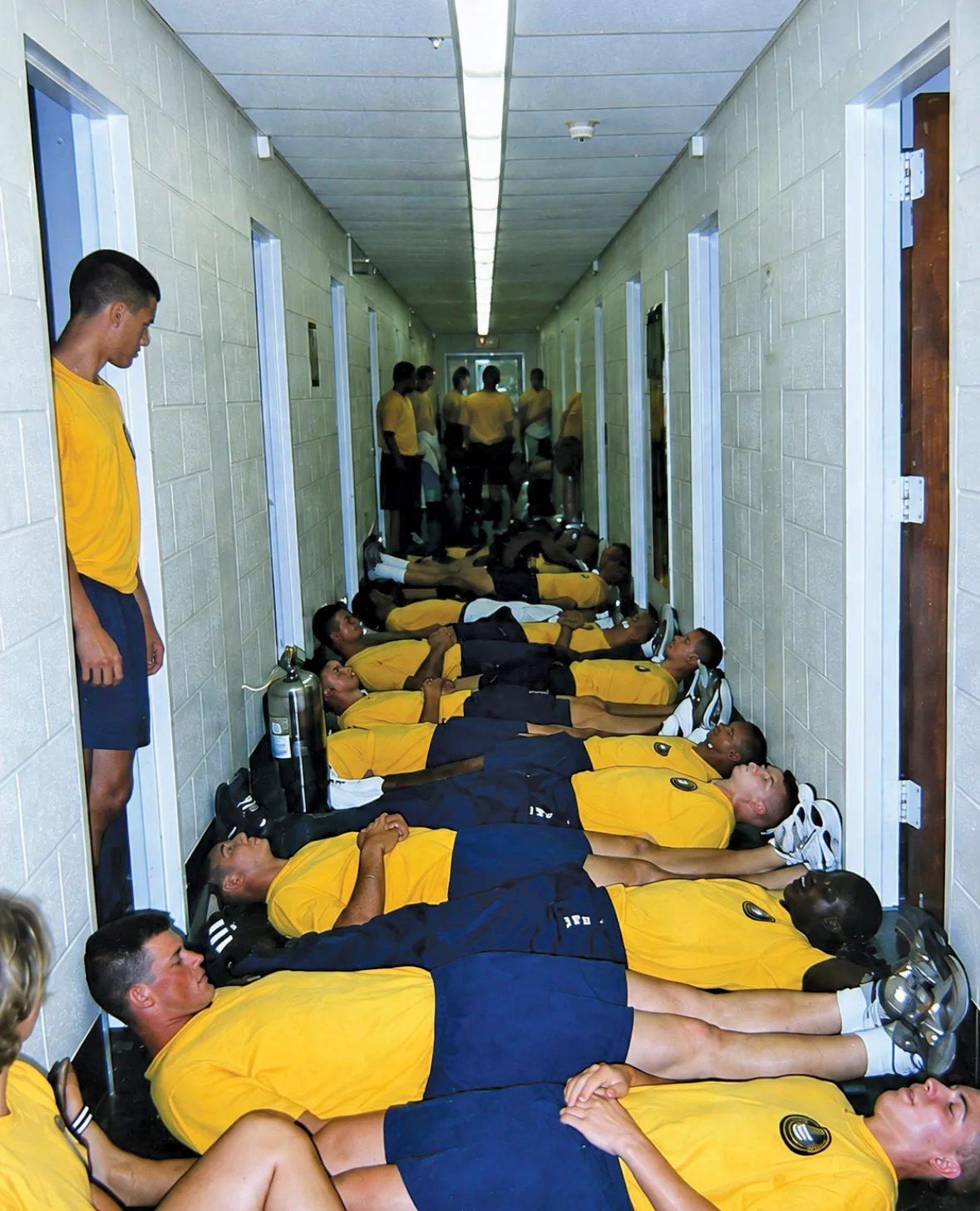 NAPS candidates line a barracks hallway floor lying side-by-side